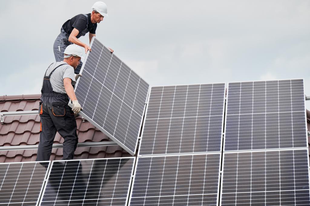 Männer montieren Solarmodule auf dem Dach